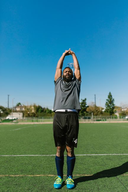 Athlete performing a single-leg balance exercise while a clinician observes movement and posture.